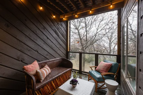 a balcony with wooden floor and outdoor seating