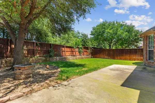 a view of a yard with wooden fence