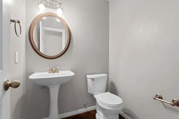a bathroom with a toilet sink and mirror