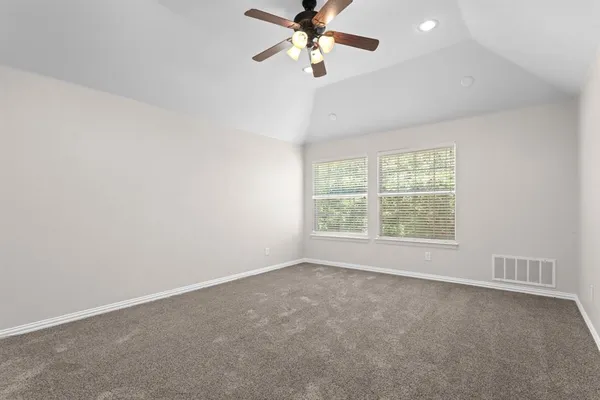 an empty room with a window and a fan