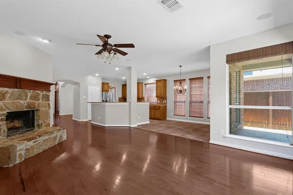 a view of an empty room with a fireplace and windows