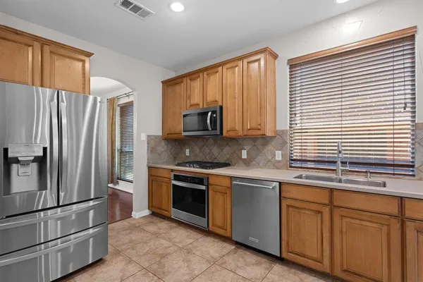 a kitchen with stainless steel appliances granite countertop a refrigerator sink and stove