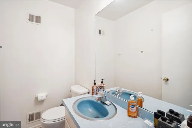 a bathroom with a sink a toilet and a mirror