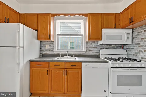 a kitchen with granite countertop cabinets stainless steel appliances a sink and a window