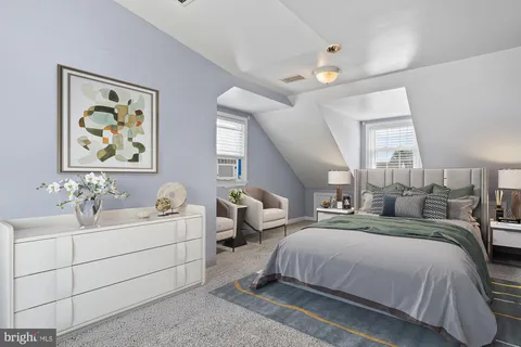 a spacious bedroom with a bed a couch and a window