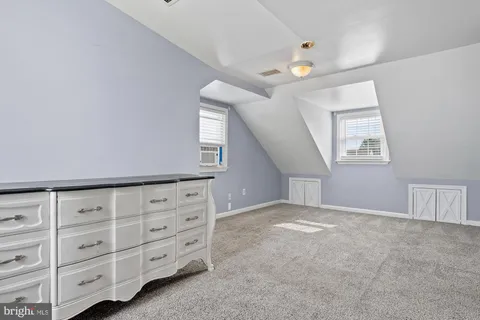 a view of an empty room with a window and cabinet