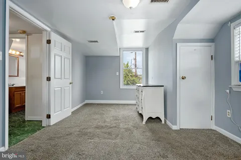 an empty room with windows and wardrobe