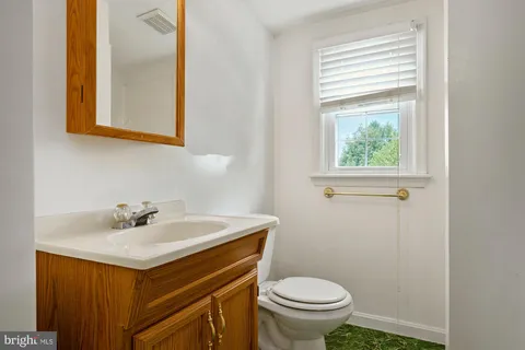 a bathroom with a sink a toilet and a mirror