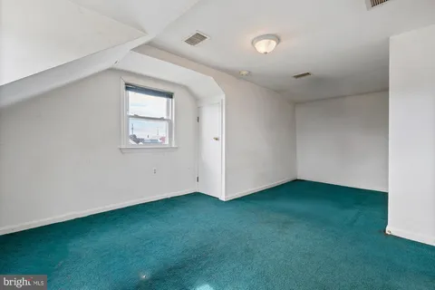 a view of an empty room with closet and a window
