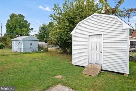 a view of a white house with a yard and a garden