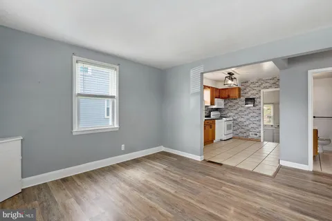 a view of empty room with wooden floor and entryway