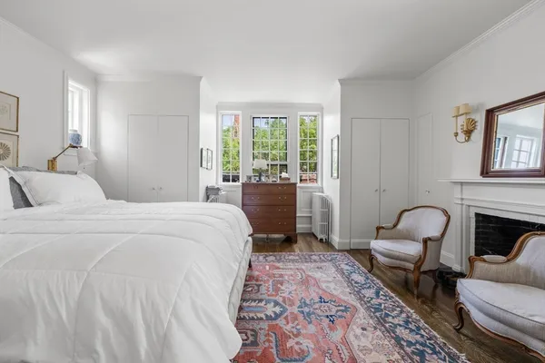 a bedroom with a bed chair and a large window