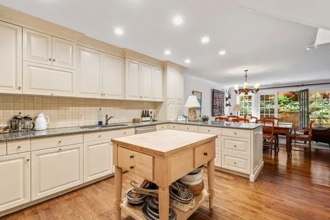 a view of a dining room with furniture a chandelier and wooden floor