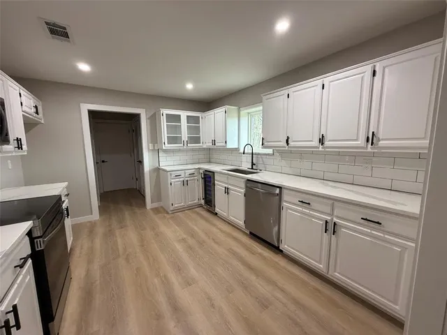 a kitchen with a sink window and cabinets