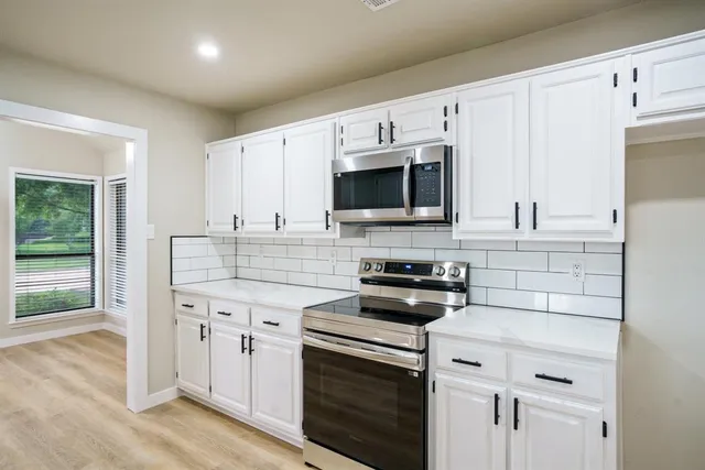 a kitchen with stainless steel appliances a stove microwave and sink