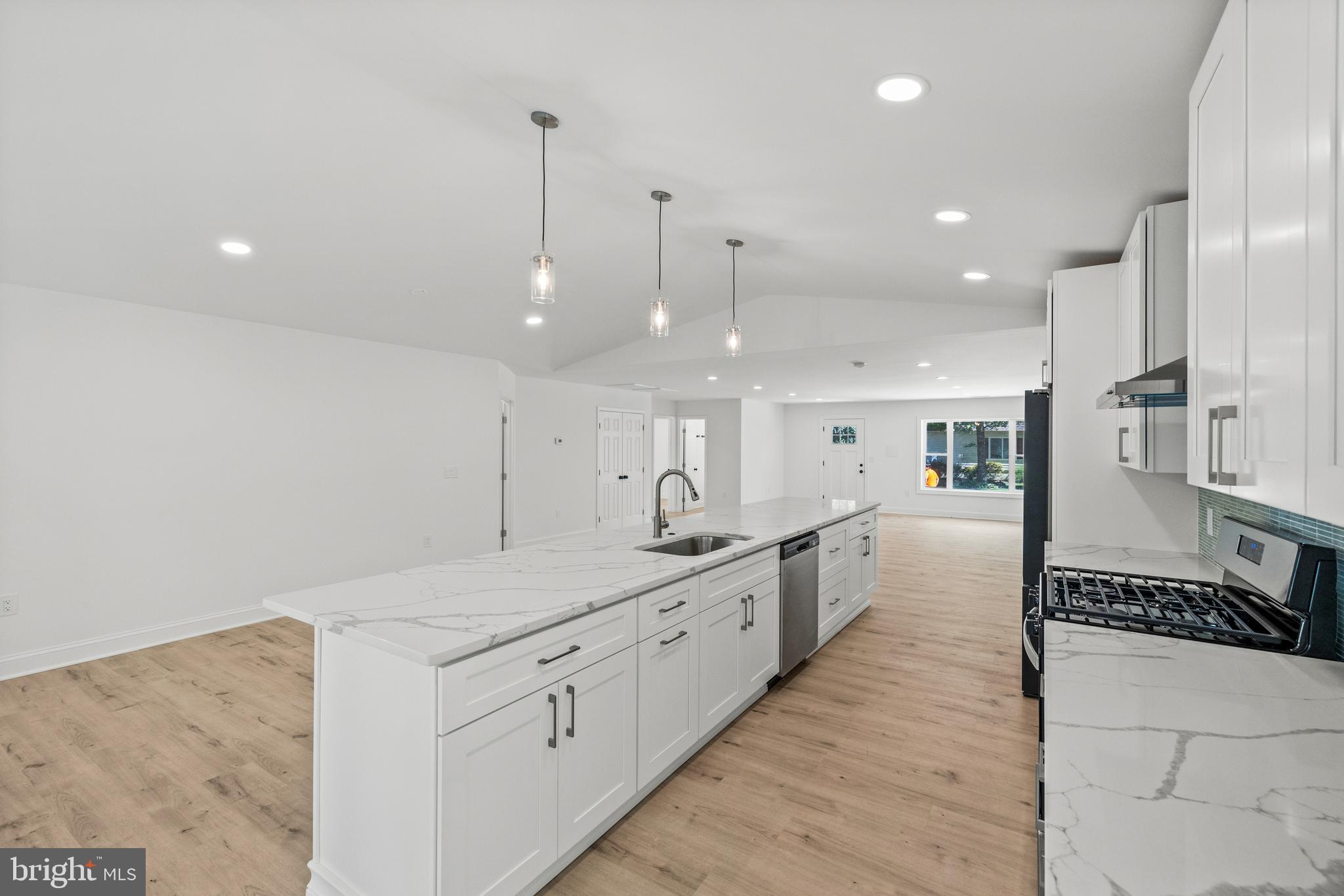 7129 Catlett Street Springfield, VA 22151 - Photo 11 of 34 a large kitchen with kitchen island a large counter space a sink appliances and cabinets