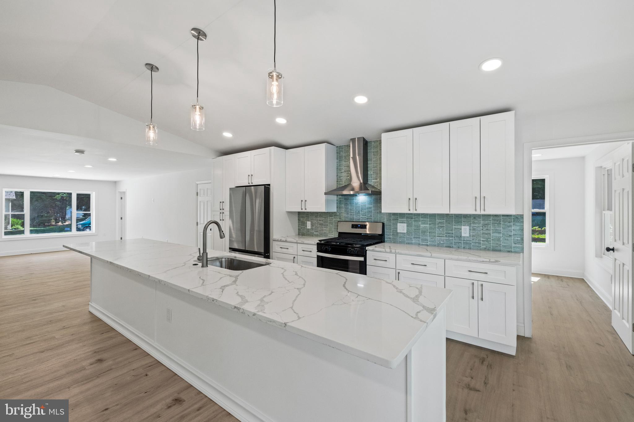 7129 Catlett Street Springfield, VA 22151 - Photo 12 of 34 a kitchen with stainless steel appliances granite countertop a sink a stove and a wooden floors