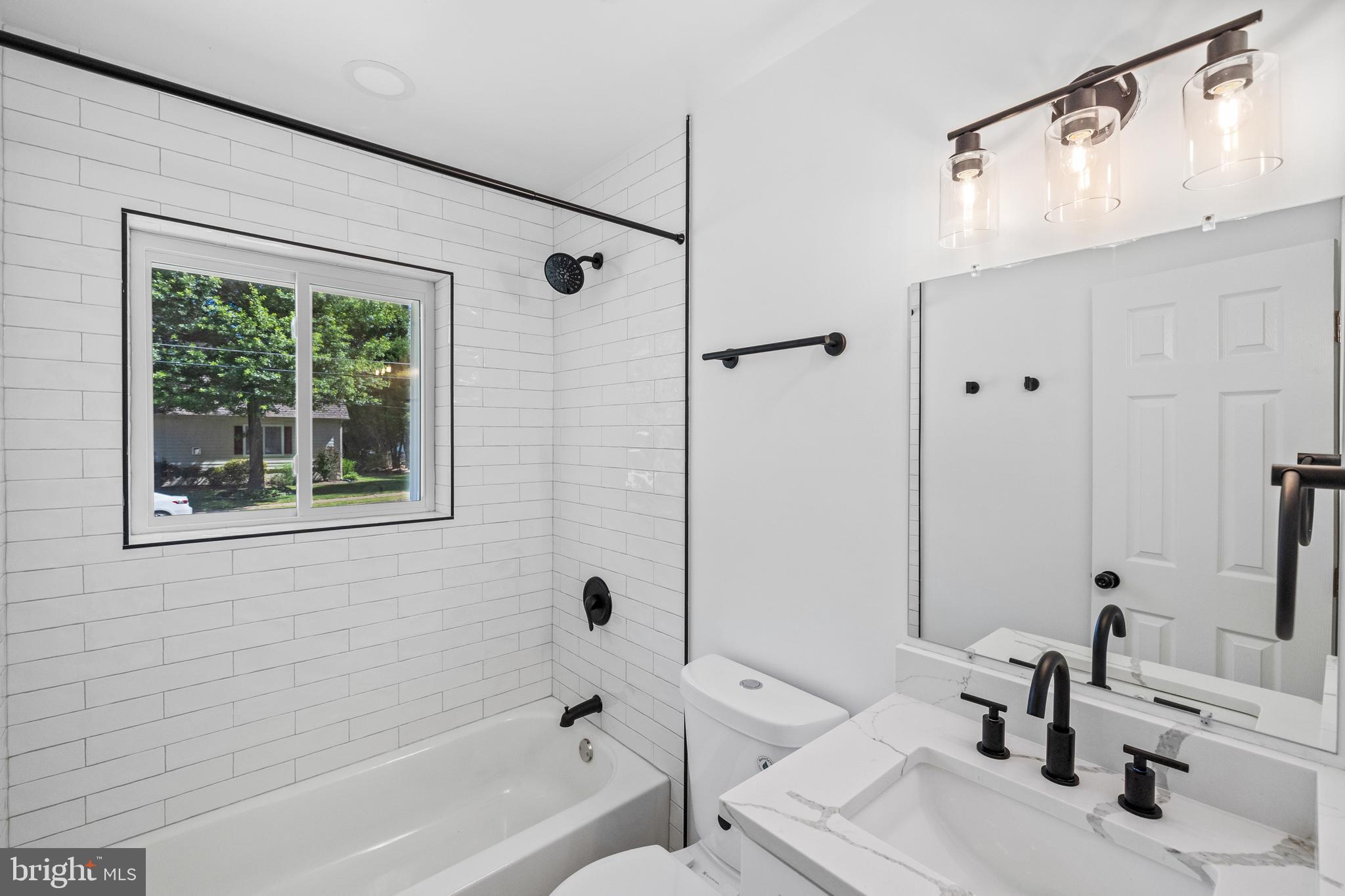7129 Catlett Street Springfield, VA 22151 - Photo 21 of 34 a bathroom with a tub sink and a mirror
