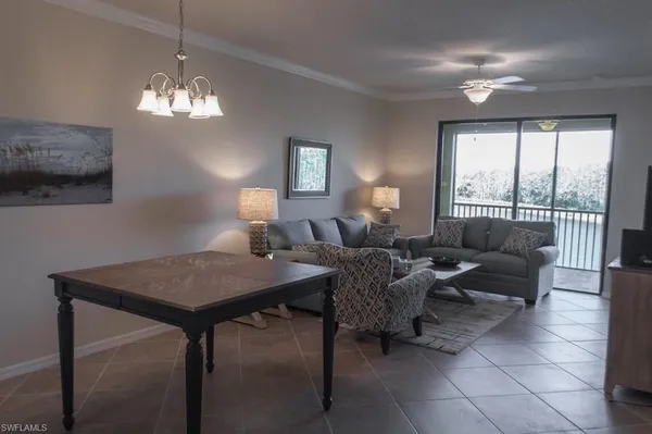 a view of a dining room with furniture a chandelier and window