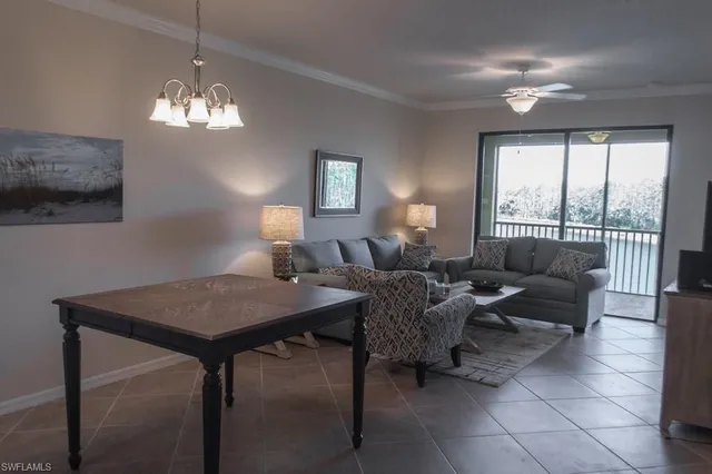 a view of a dining room with furniture a chandelier and window