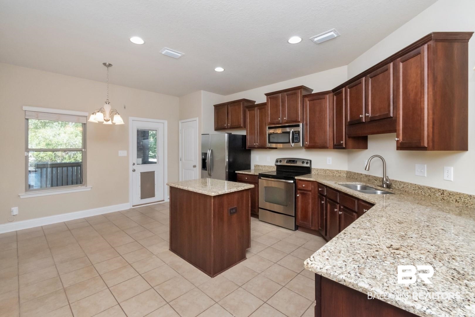 6144 Whitebark Drive Mobile, AL 36693 - Photo 11 of 33 Kitchen featuring pendant lighting, a center island, sink, a notable chandelier, and stainless steel appliances