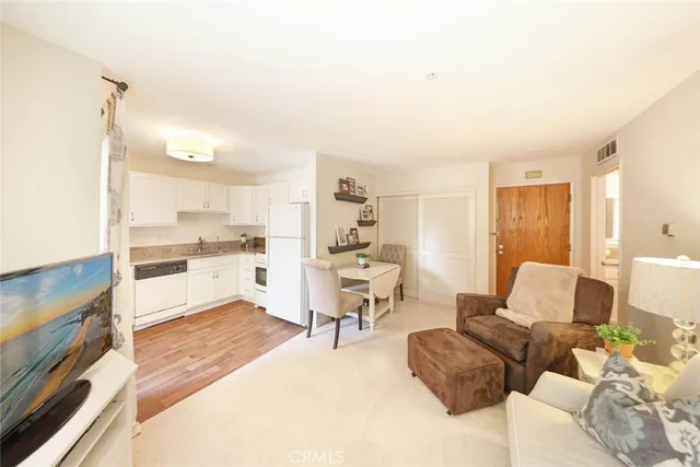 a living room with furniture and a kitchen view