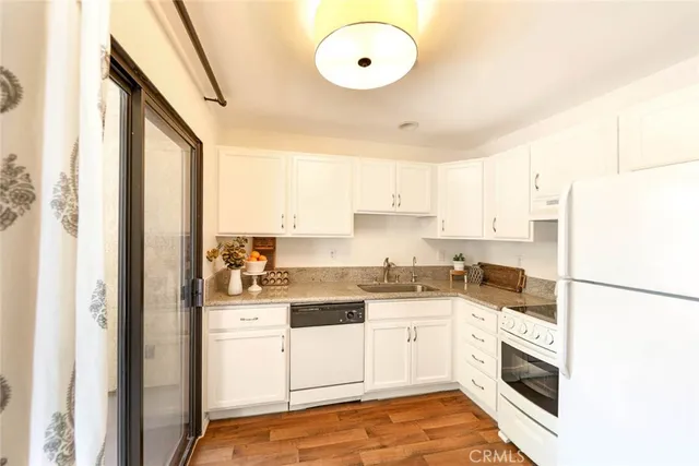 a kitchen with a sink a refrigerator and cabinets
