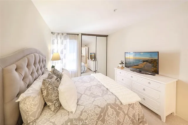 a bedroom with a bed and a flat screen tv