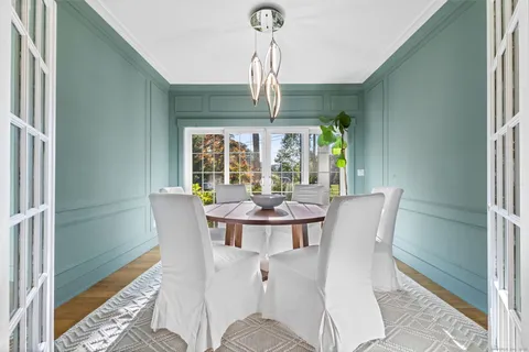 a dining room with furniture a chandelier and wooden floor