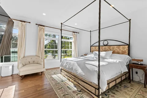 a bedroom with a bed couch and a window