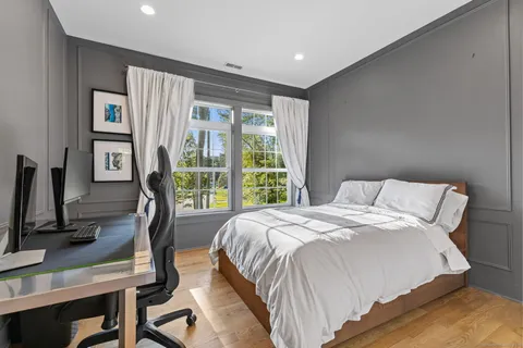 a bedroom with a bed a flat screen tv and a large window