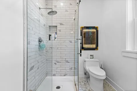 a bathroom with a toilet and a shower