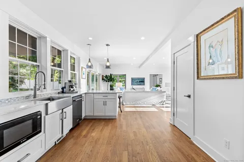 a large kitchen with a large window a sink and stainless steel appliances
