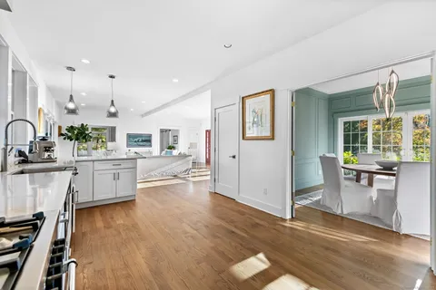 a kitchen with wooden floors and white cabinets