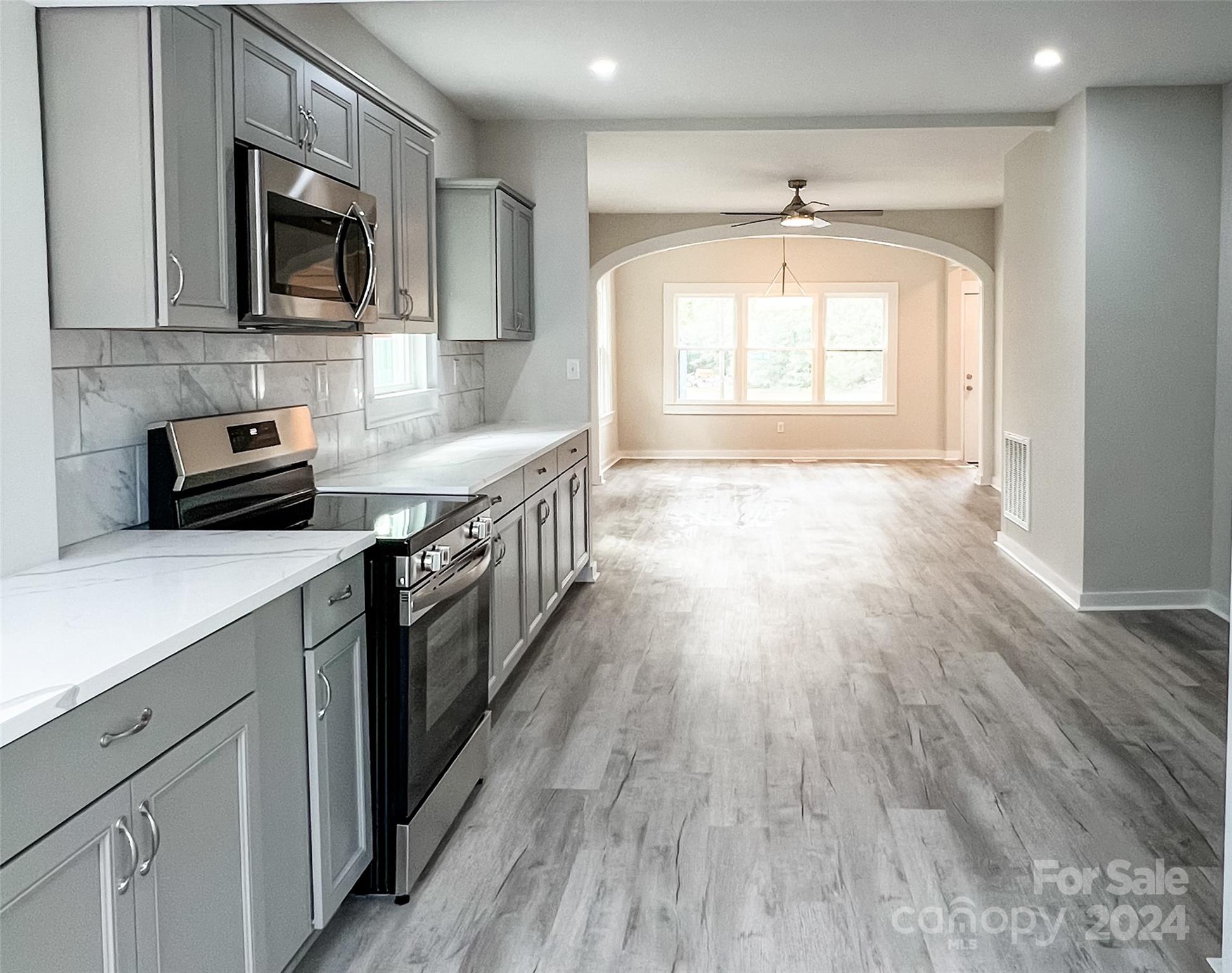 816 Laton Road Albemarle, NC 28001 - Photo 7 of 28 a kitchen with stainless steel appliances wooden floors and wooden cabinets