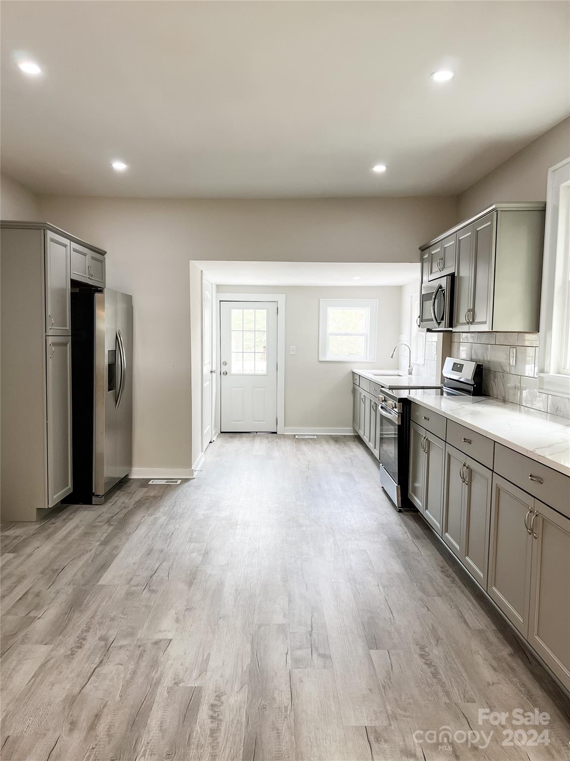 816 Laton Road Albemarle, NC 28001 - Photo 10 of 28 a large kitchen with stainless steel appliances granite countertop a lot of counter space and wooden floors