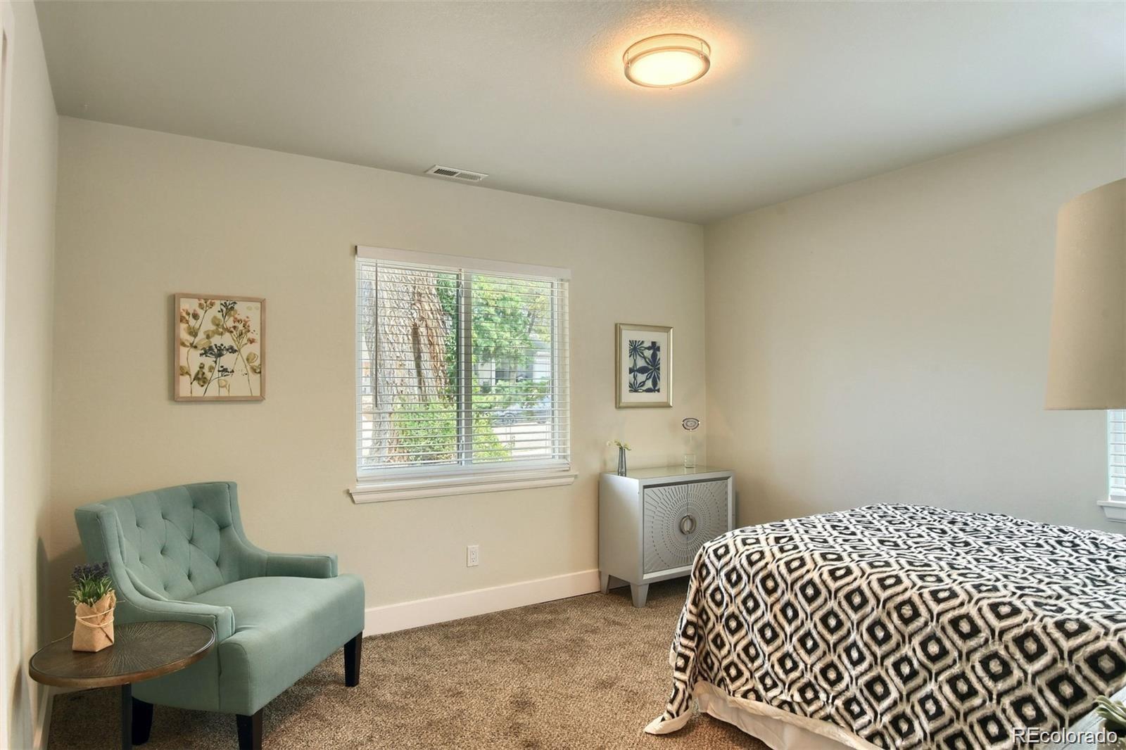 3075 South Grape Way Denver, CO 80222 - Photo 17 of 25 a bedroom with a bed and wooden floor