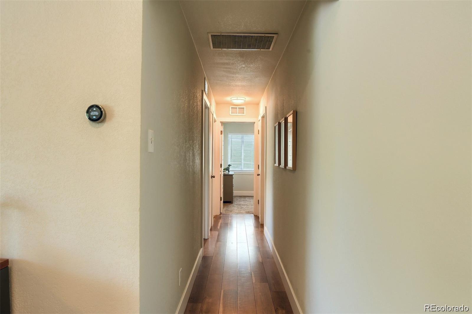 3075 South Grape Way Denver, CO 80222 - Photo 22 of 25 a view of a hallway with wooden floor and a bathroom