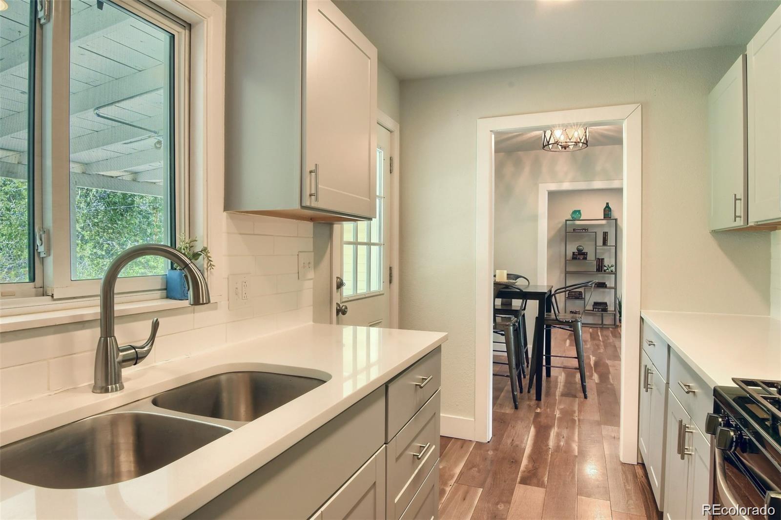 3075 South Grape Way Denver, CO 80222 - Photo 7 of 25 a kitchen with a sink and a refrigerator