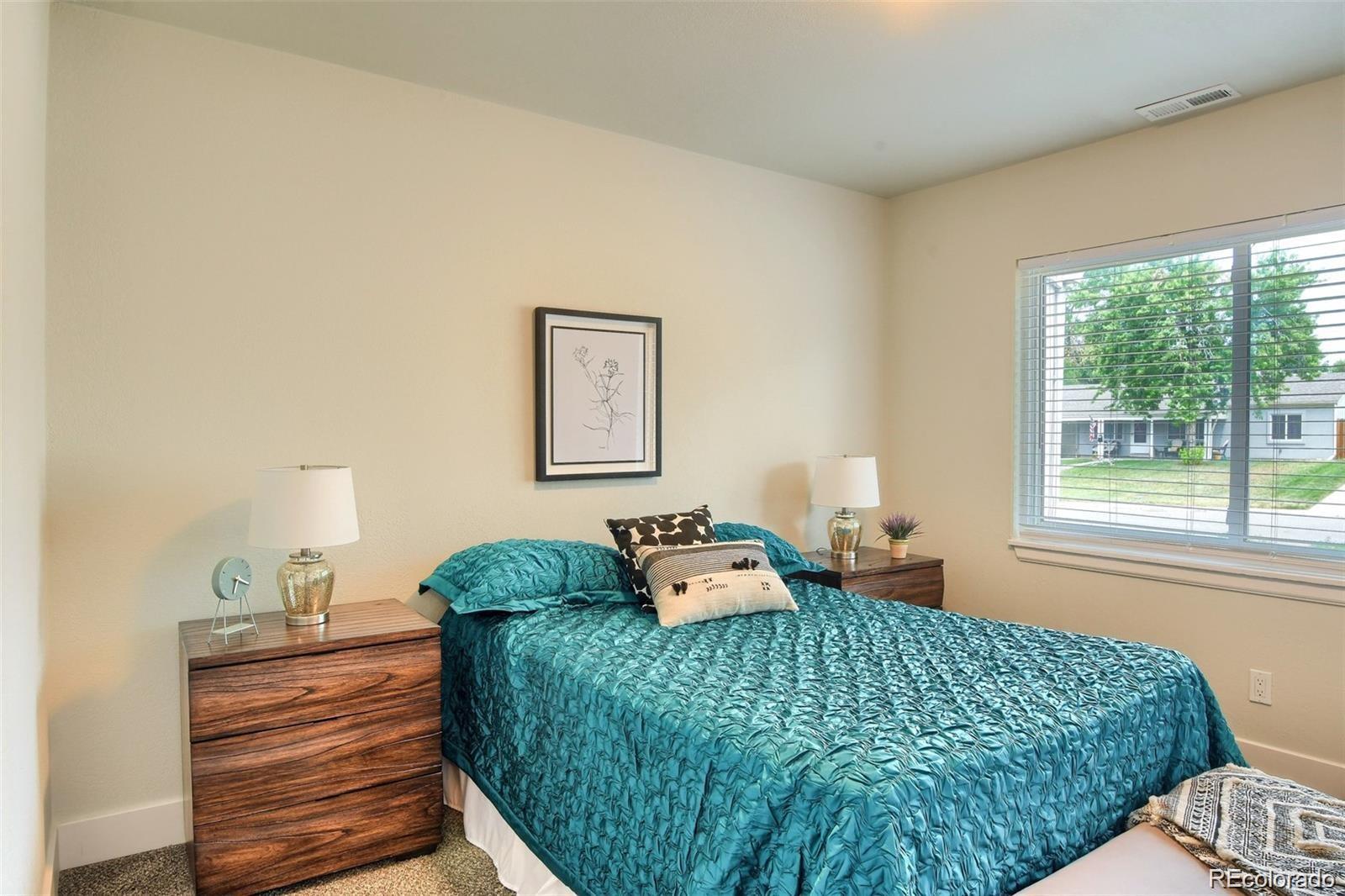 3075 South Grape Way Denver, CO 80222 - Photo 10 of 25 a bedroom with a bed and wooden floor