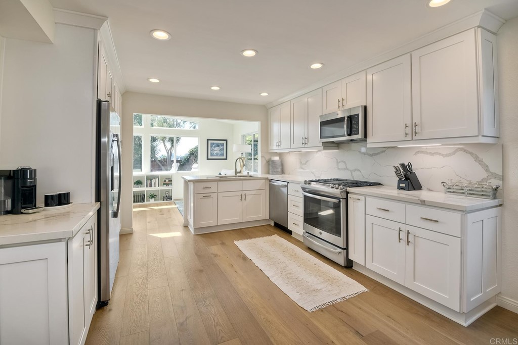 631 Dell Street Solana Beach, CA 92075 - Photo 16 of 36 a kitchen with a white stove top oven and white cabinets