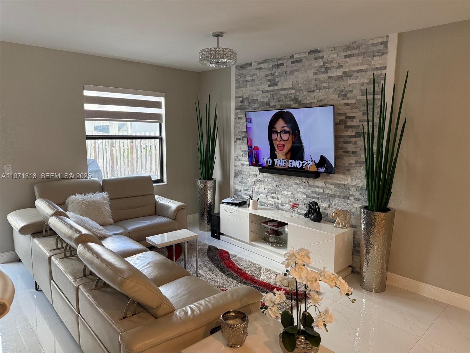 25265 Southwest 109th Avenue, Unit 25265 Homestead, FL 33032 - Photo 11 of 18 a living room with furniture and a fireplace