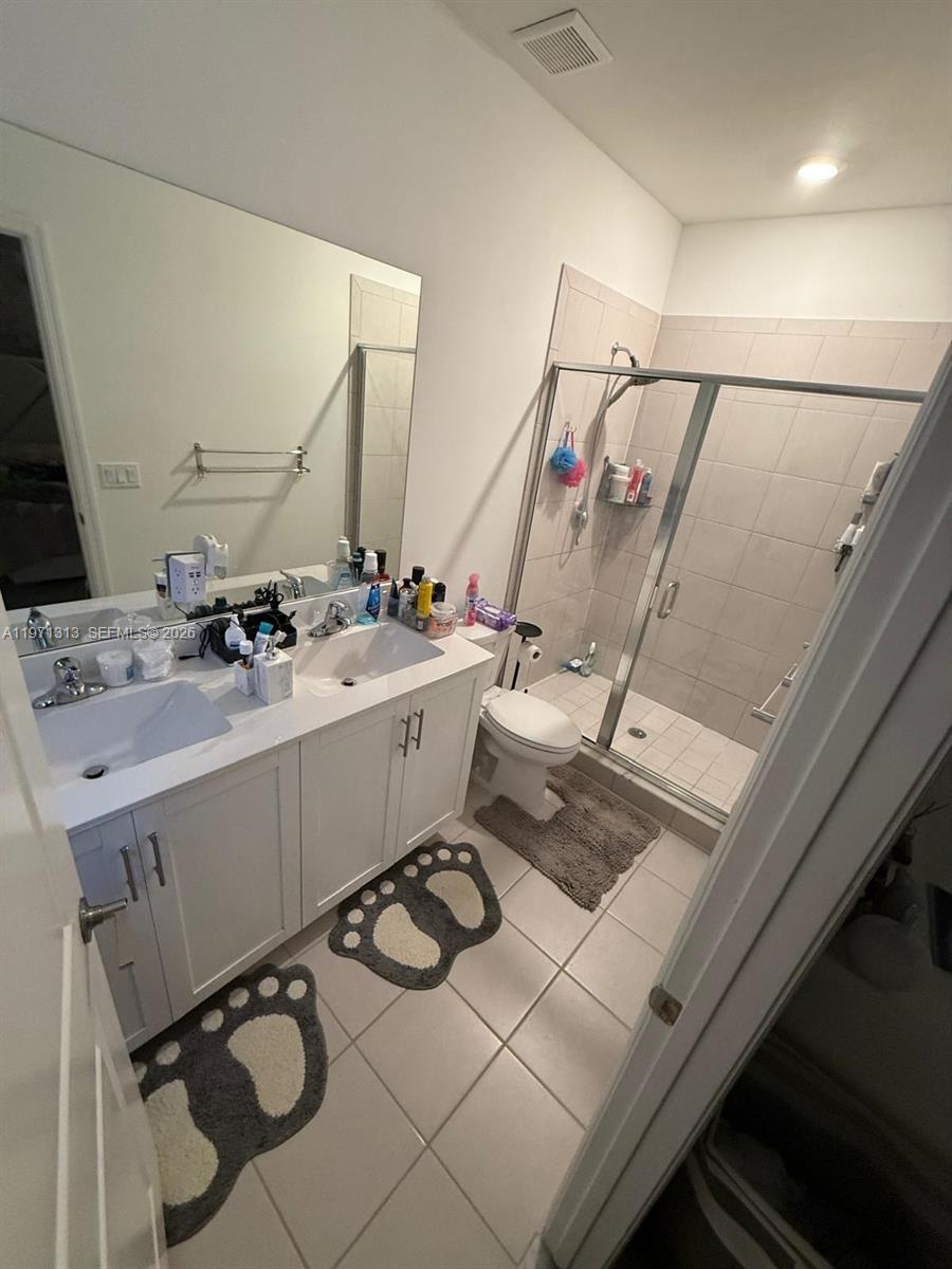 25265 Southwest 109th Avenue, Unit 25265 Homestead, FL 33032 - Photo 15 of 18 a bathroom with a sink mirror and toilet