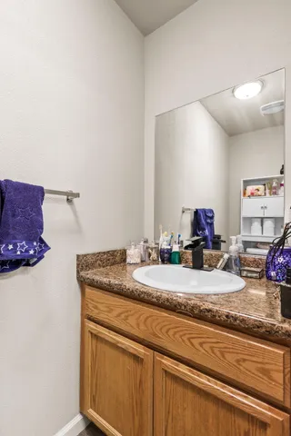 a bathroom with a granite countertop sink and a mirror
