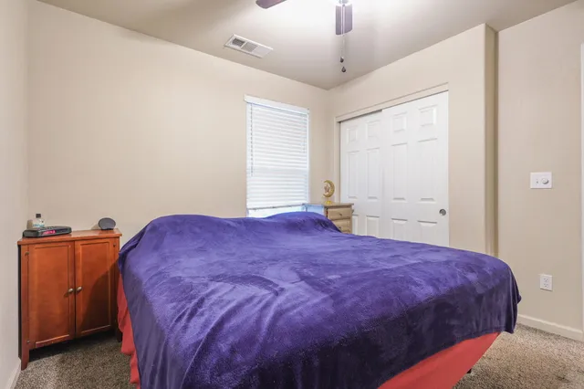 a spacious bedroom with a bed and a dresser