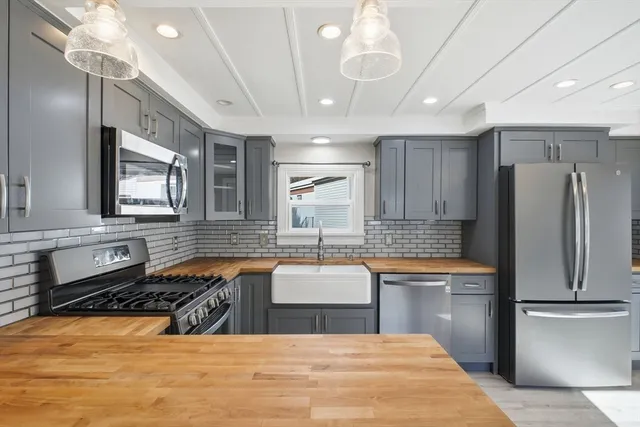 a kitchen with stainless steel appliances granite countertop a sink stove and refrigerator