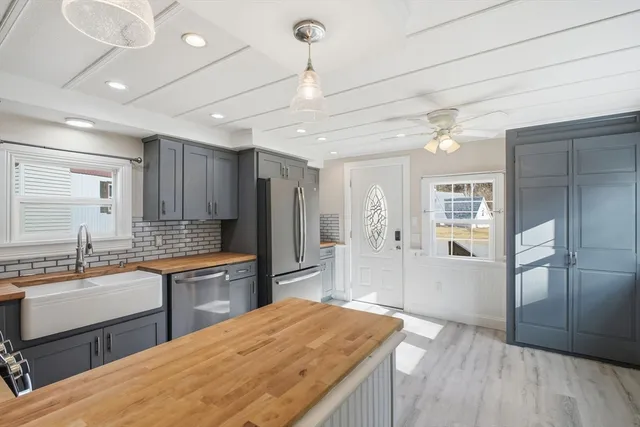 a kitchen with stainless steel appliances granite countertop a sink refrigerator and cabinets