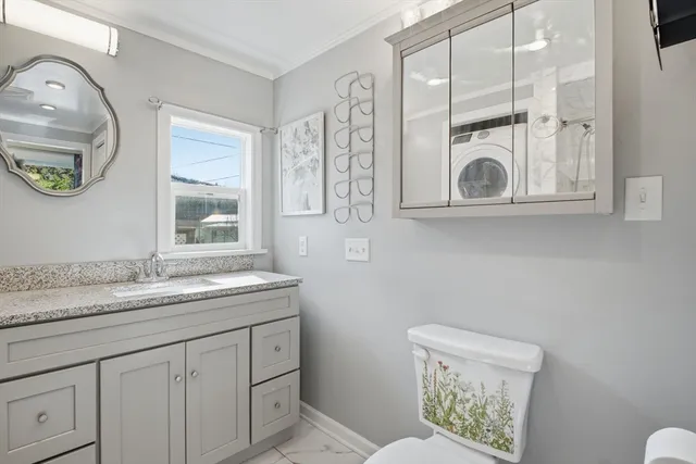 a bathroom with a granite countertop sink mirror vanity and toilet
