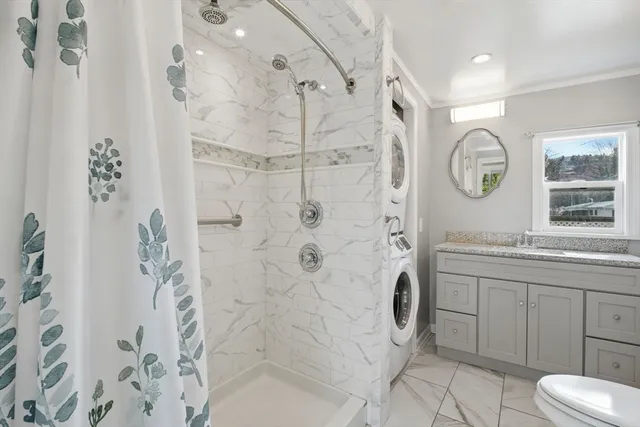 a bathroom with a granite countertop sink a toilet and shower