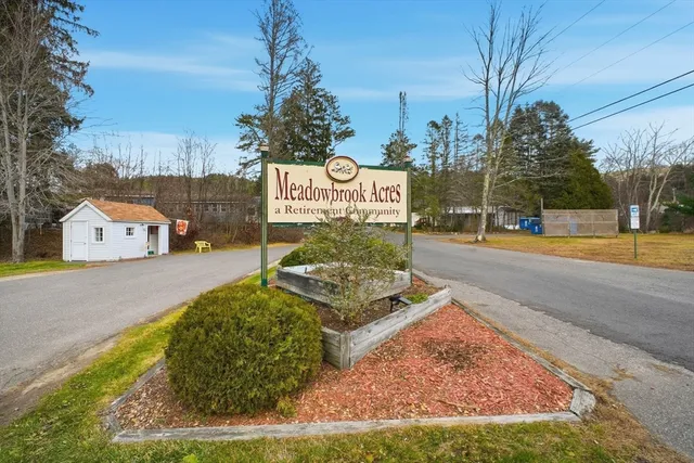 a sign board with buildings in the background